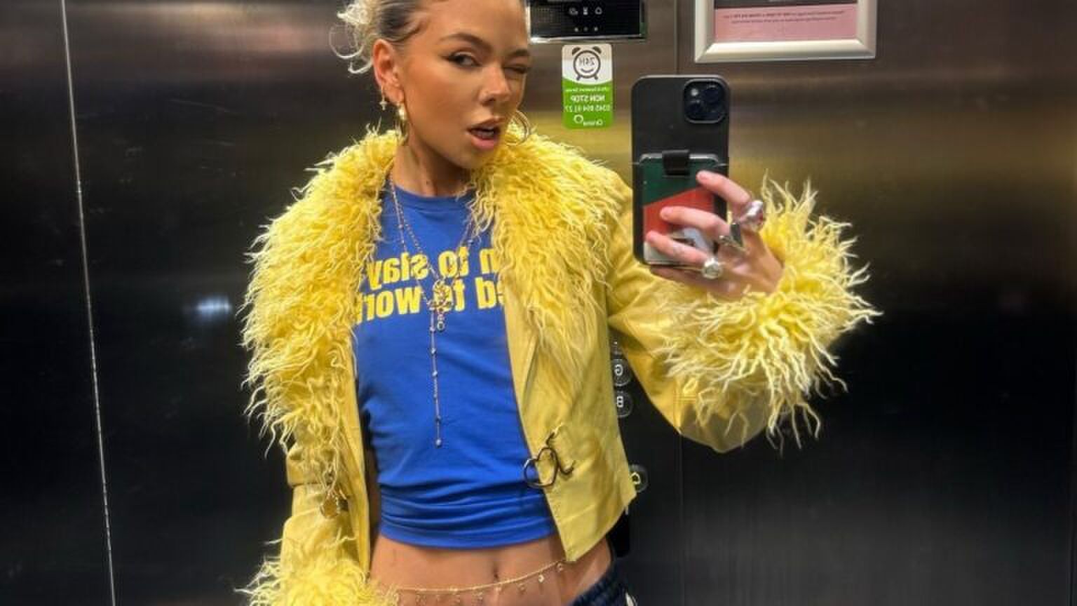 Een meisje maakt een liftselfie met een belly chain om.