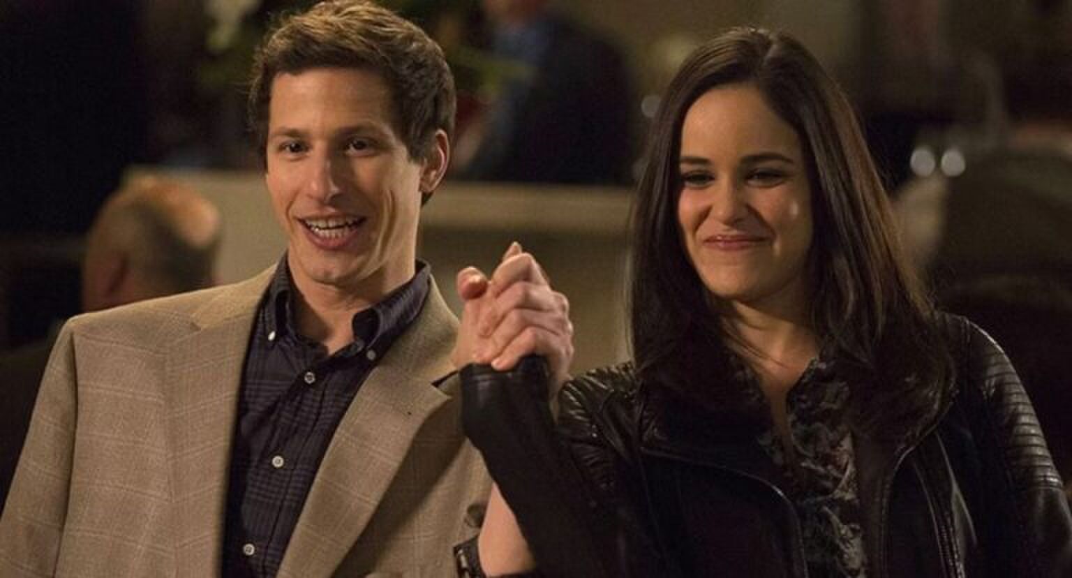 Man en vrouw houden triomfantelijk hun handen ineengeslagen omhoog.