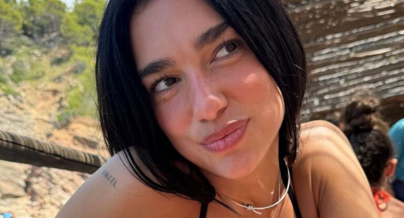 Vrouw kijkt weg van camera op zomers oord.