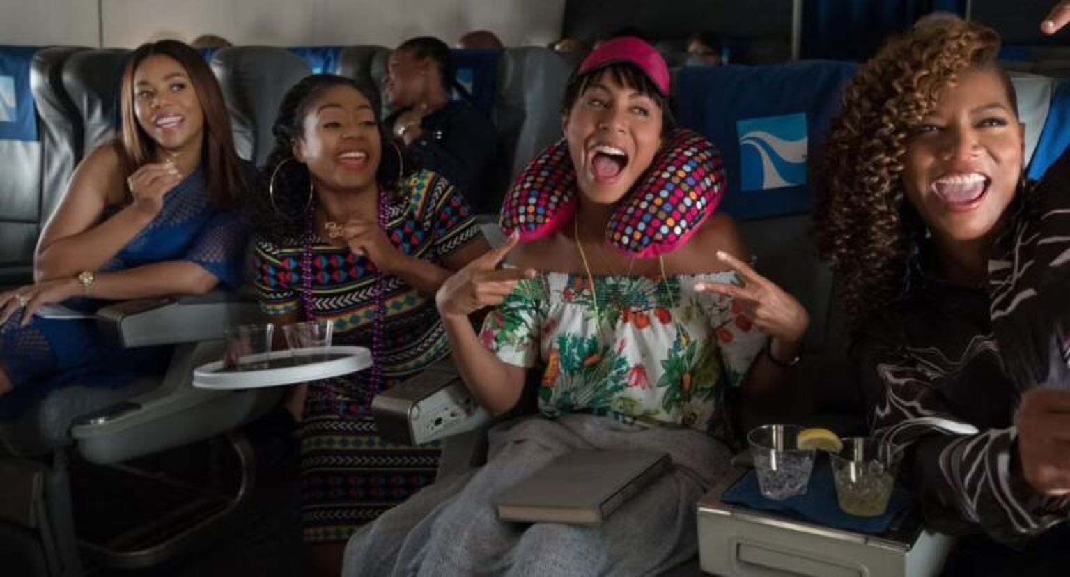 Vier meiden zitten vrolijk in het vloegtuig.