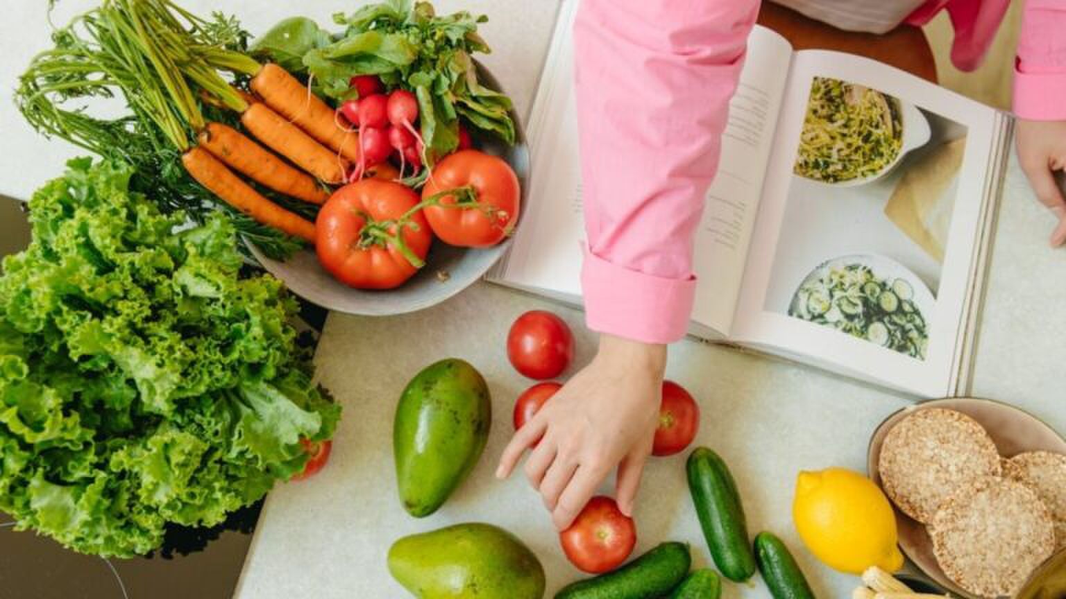 Iemand die aan het koken is met een kookboek.