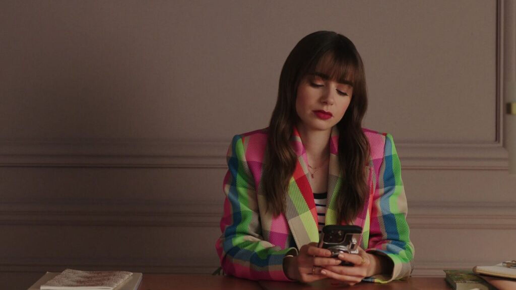 Emily uit Emily in Paris op haar telefoon.