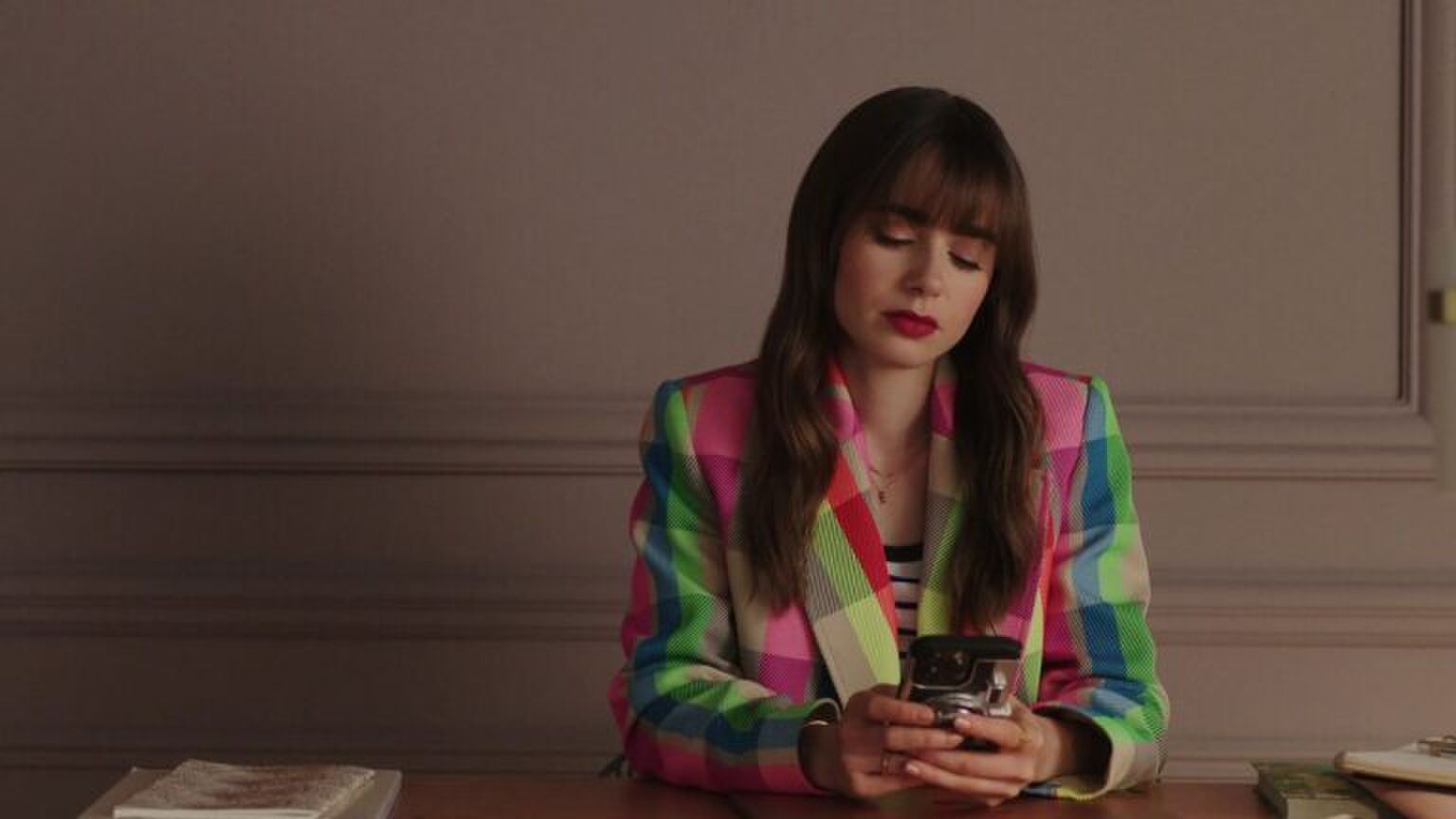 Emily uit Emily in Paris op haar telefoon.