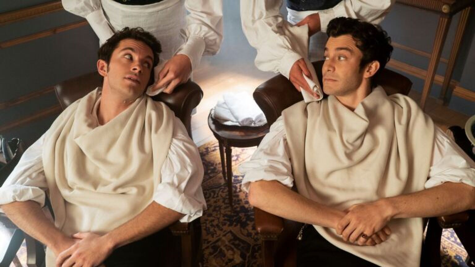 Sc&egrave;ne uit Bridgerton waar Anthony en Benedict in kappersstoelen zitten.