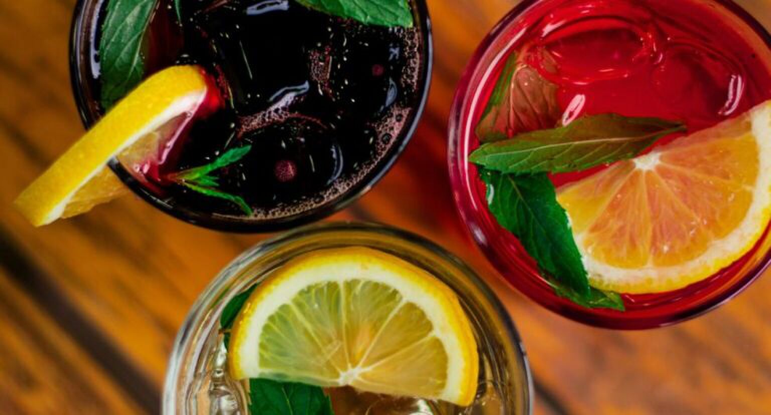 Drie glazen met kleurrijke drankjes er in.