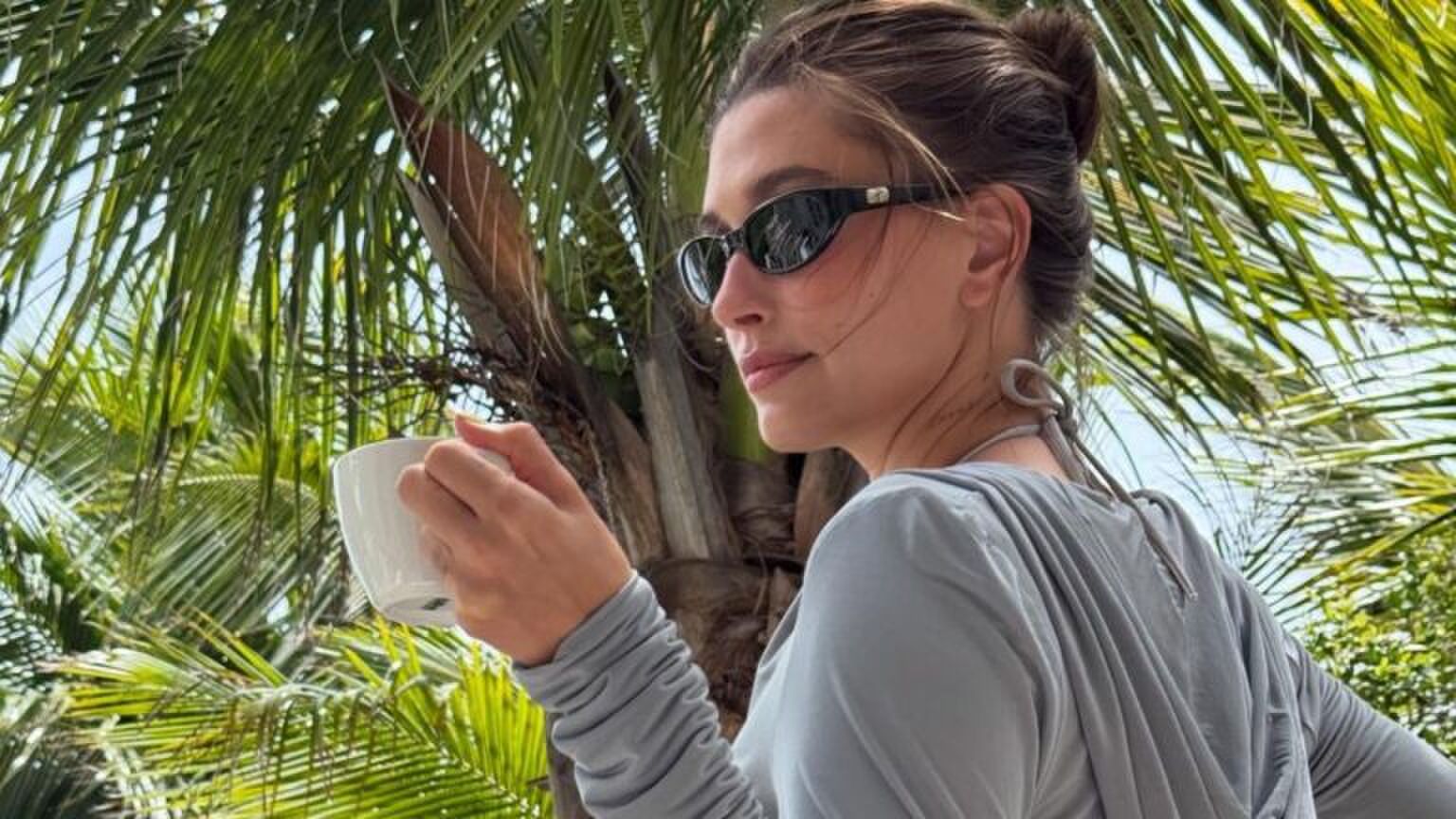 hailey bieber met zonnebril en koffie in haar hand