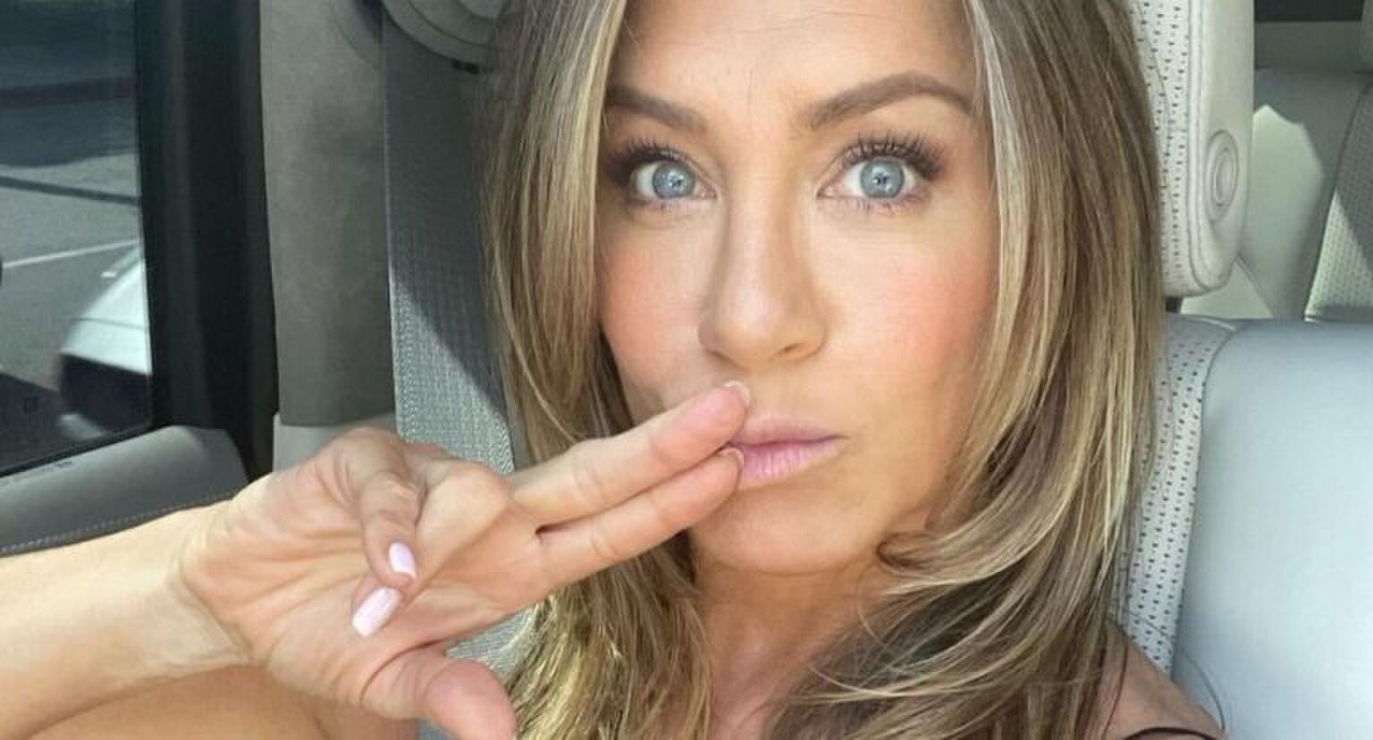 Vrouw neemt selfie in de auto.