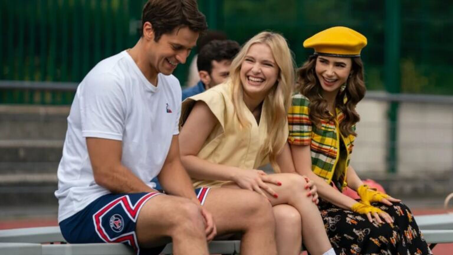 Drie mensen lachen met elkaar.