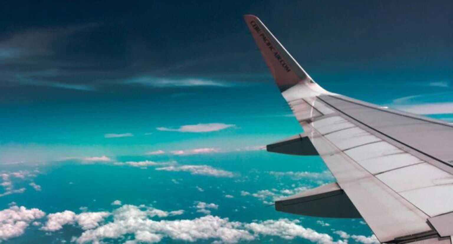 Foto van de vleugel van en vliegtuig vanuit het vliegtuig.