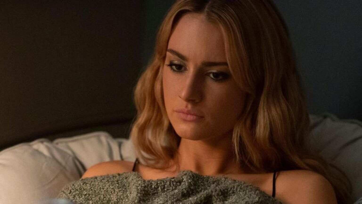 Een vrouw kijkt een beetje verloren voor zich uit.