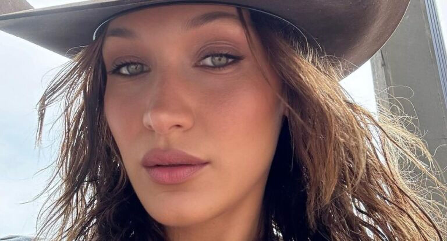 Vrouw met cowboyhoed maakt een selfie.