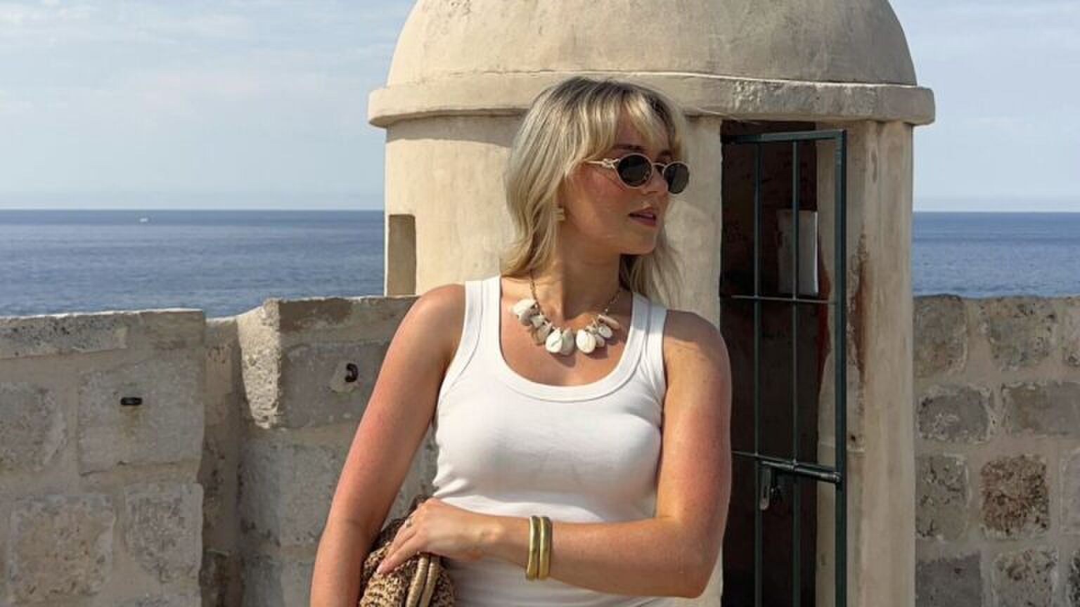 Een meisje staat aan de boulevard.