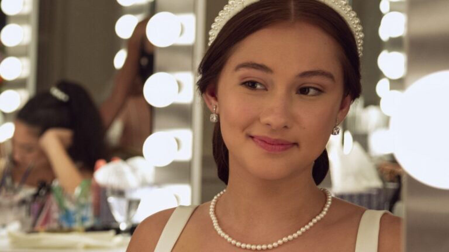 Een meisje kijkt in de spiegel en bloost.