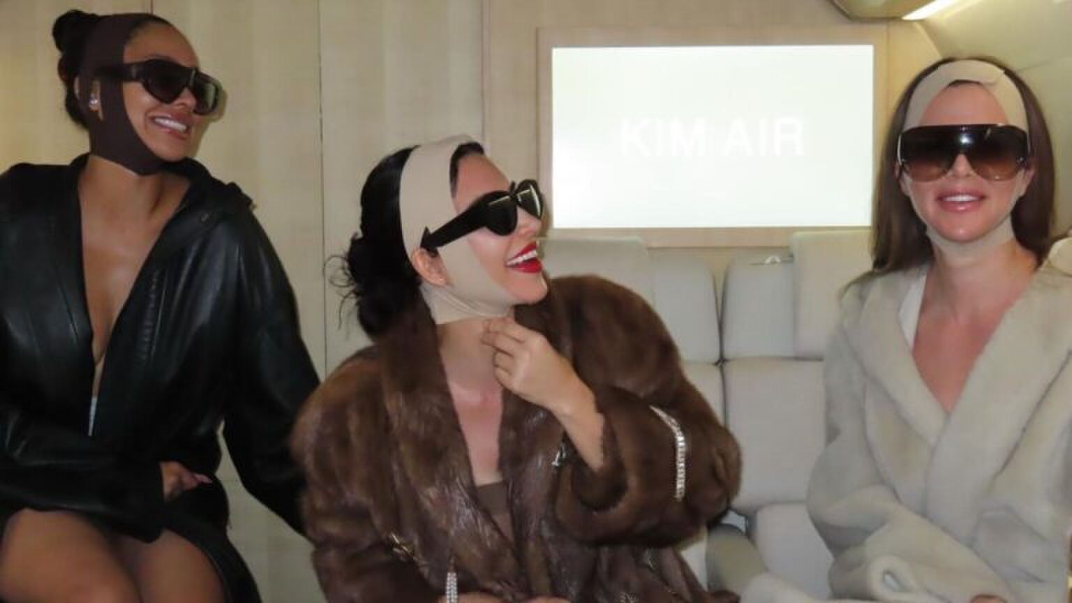 Kim Kardashian zit met haar face tape op in het vliegtuig.