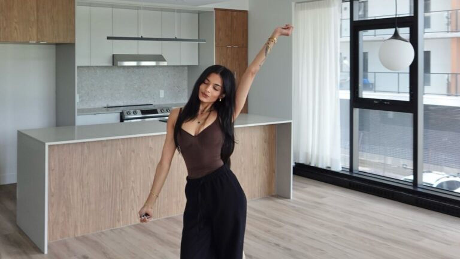 Een vrouw die in haar nieuwe appartement staat.