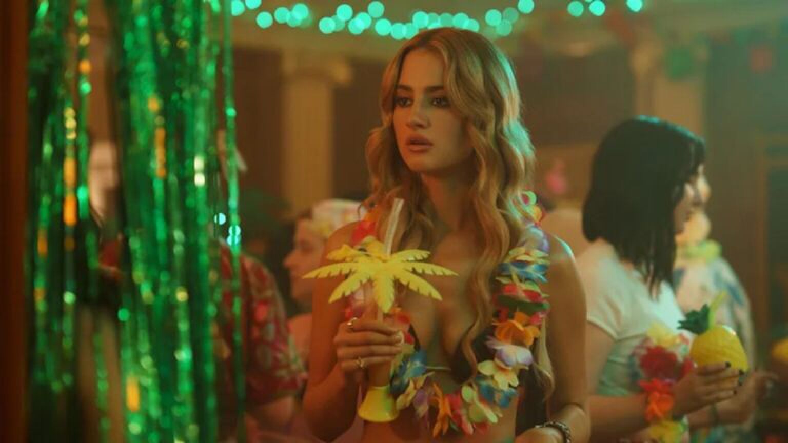 Een jonge vrouw met een cocktail in de hand.