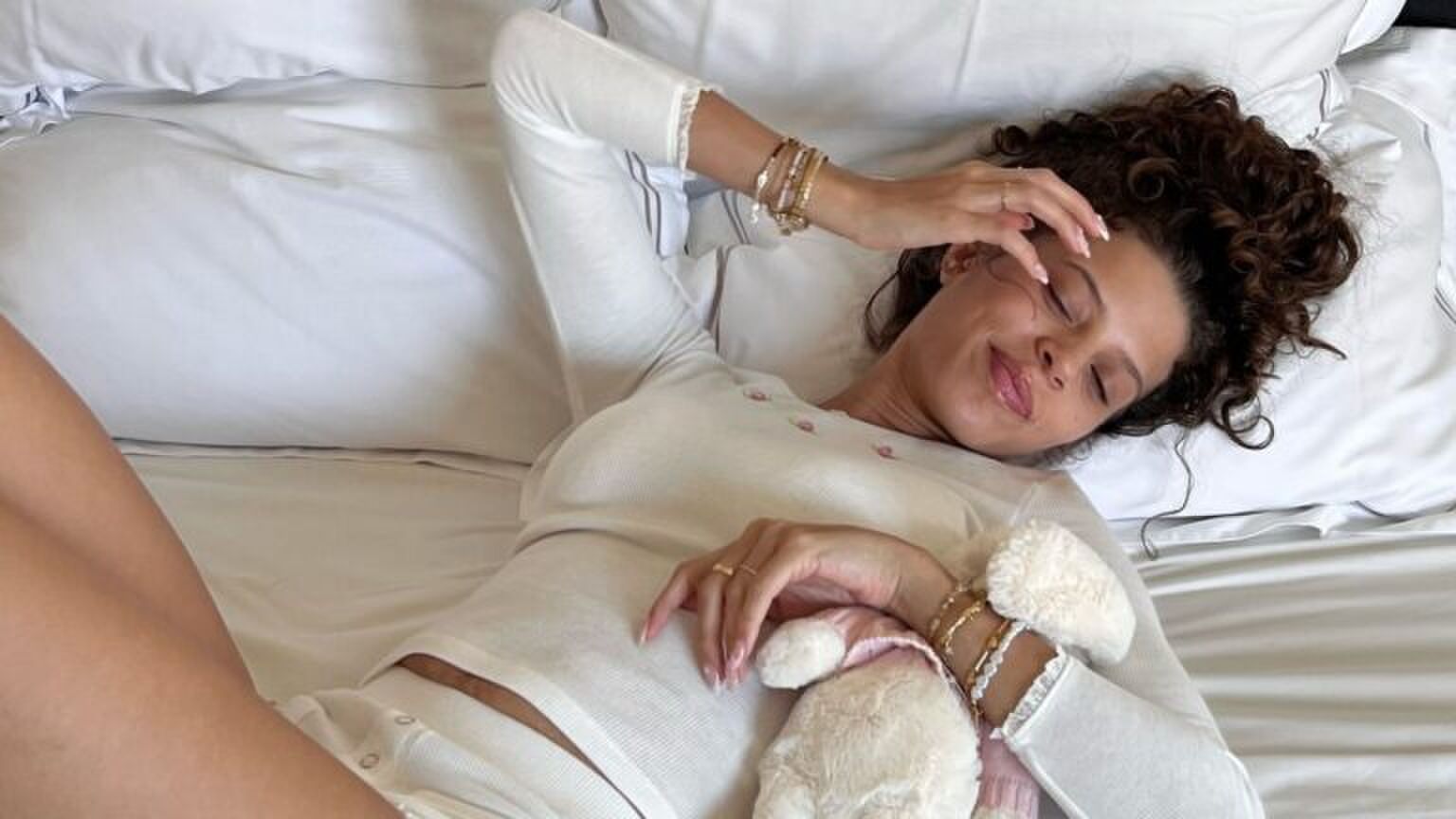 Zara Goedemans die in bed ligt met een knuffel in haar armen.