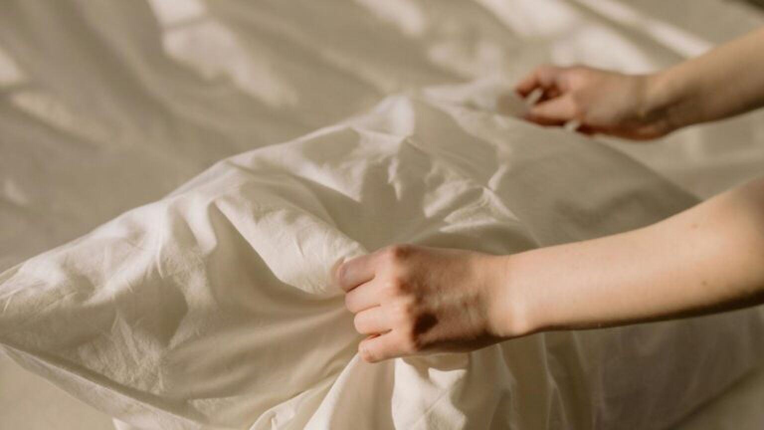 Iemand maakt haar bed op.