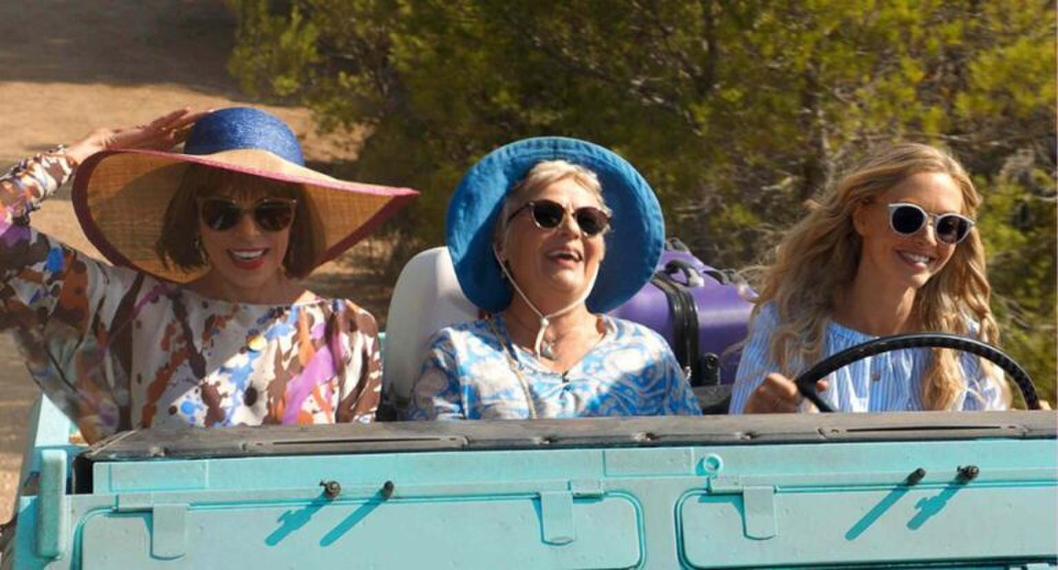 Drie vrouwen zitten in een auto met open dak.