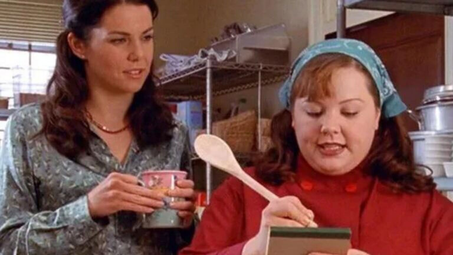 Kokkin en vriendin staan samen in een keuken. Ze schrijven iets op een briefje met een pollepel. Afbeelding uit: Gilmore Girls.