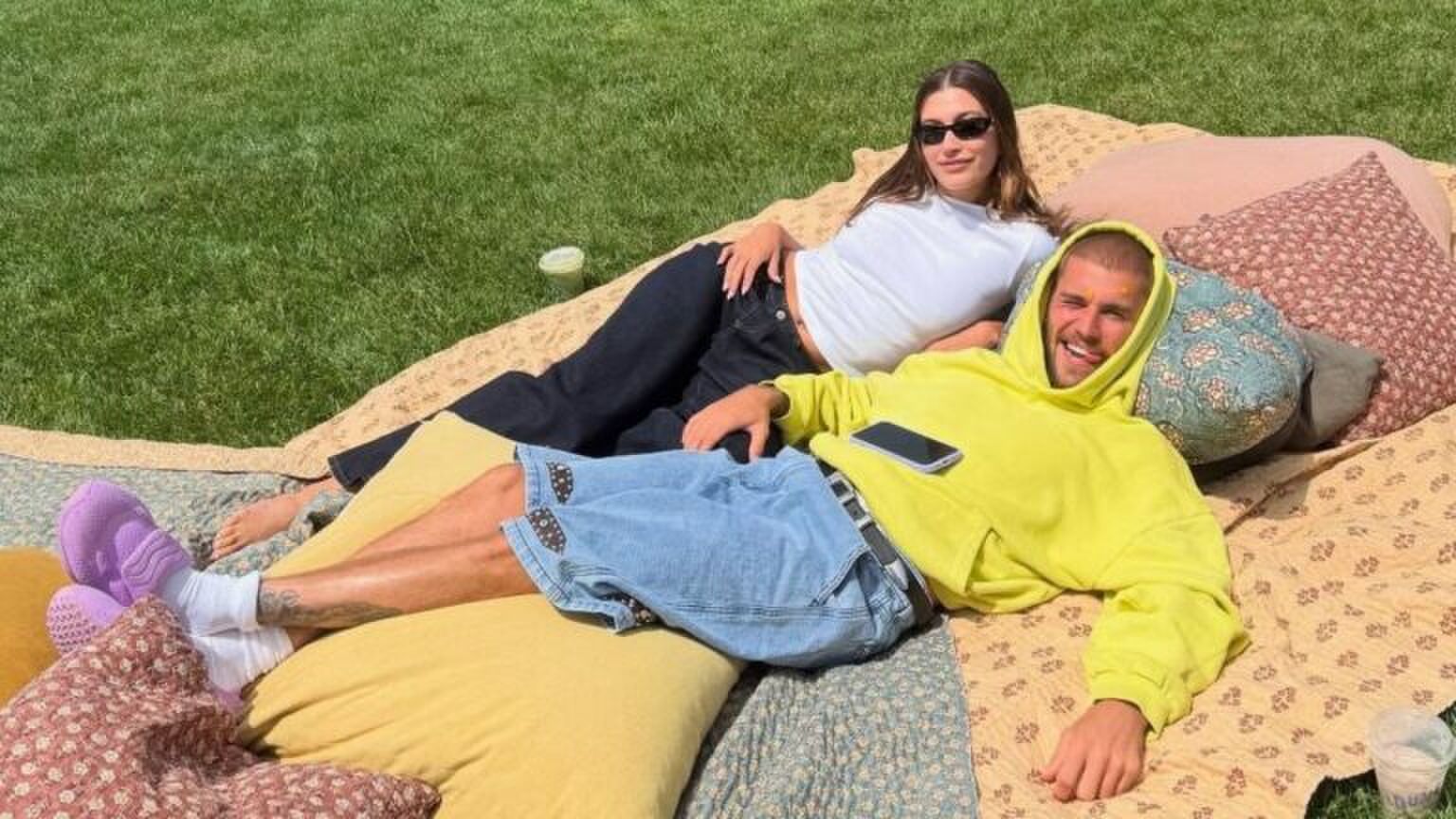 Vrouw en man liggen buiten op een picknick-kleed.