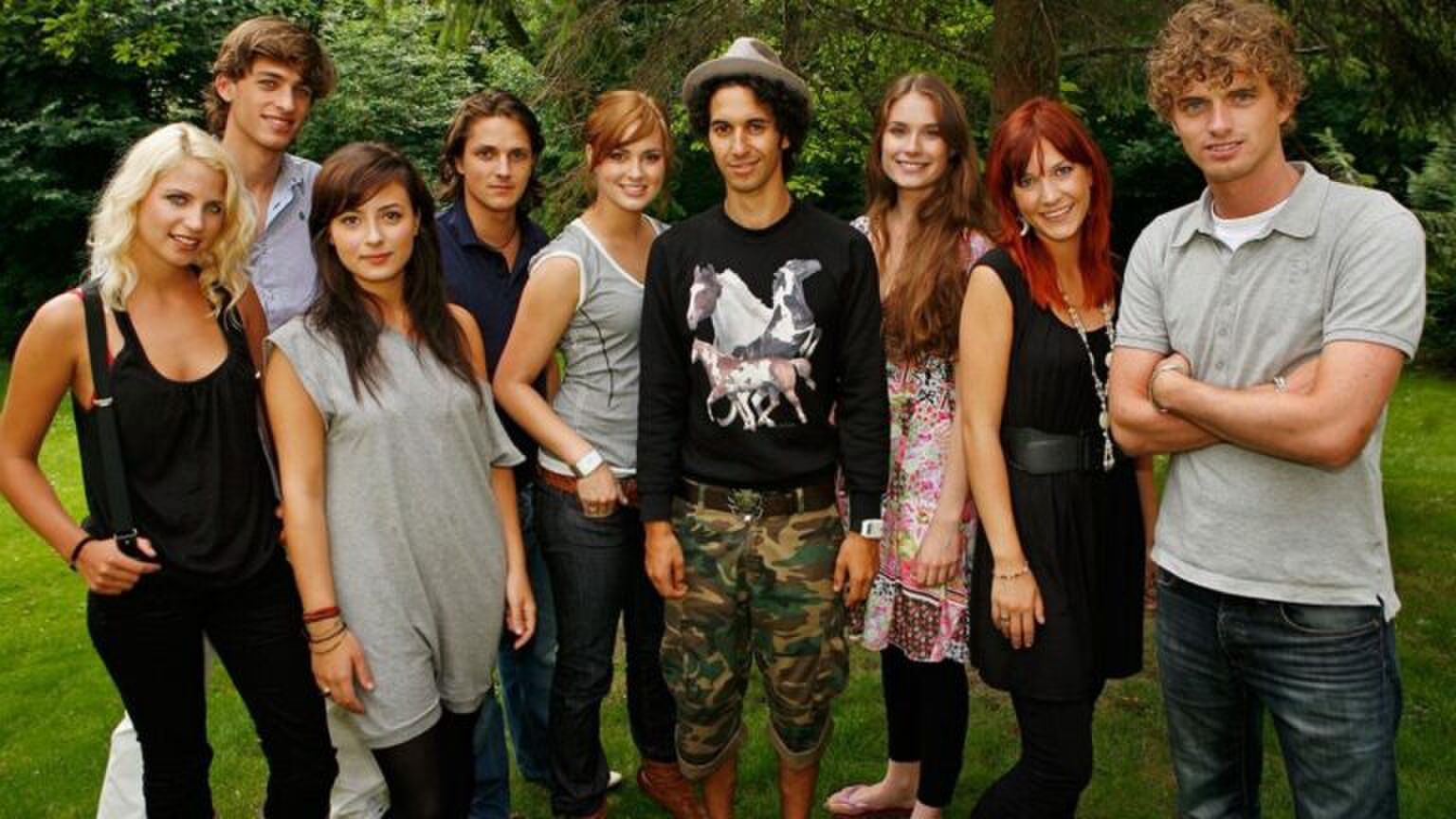 Vriendgroep staat glimlachen bij elkaar. Afbeelding uit: Het Huis Anubis.