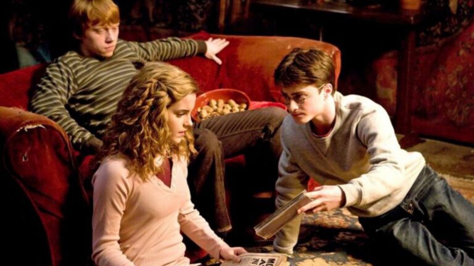 Hermione, Ron en Harry bladeren samen door nieuwsartikelen.