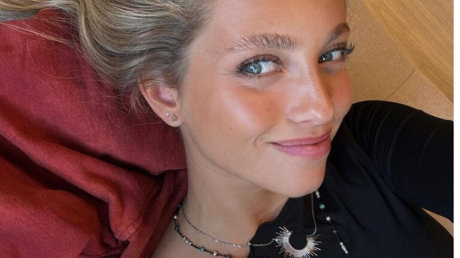 Vrouw glimlacht en kijkt opzij.