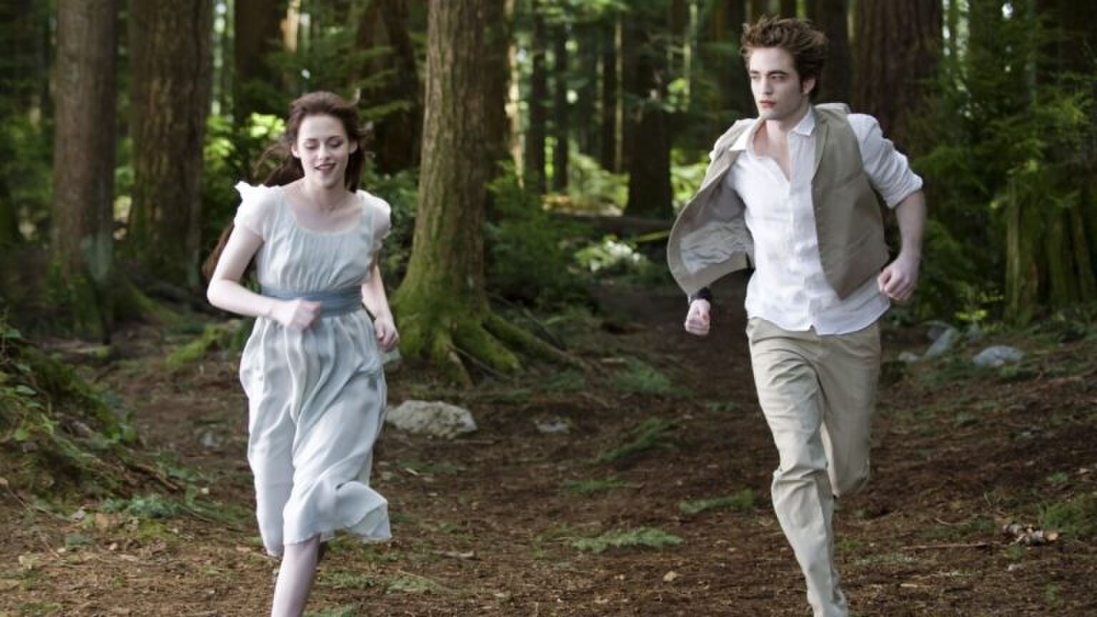 Vrouw en man rennen door het bos. Afbeelding uit Twilight.