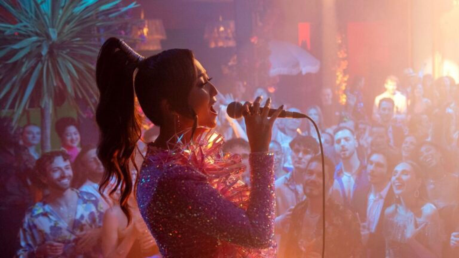 Vrouw zingt voor een grote groep mensen.