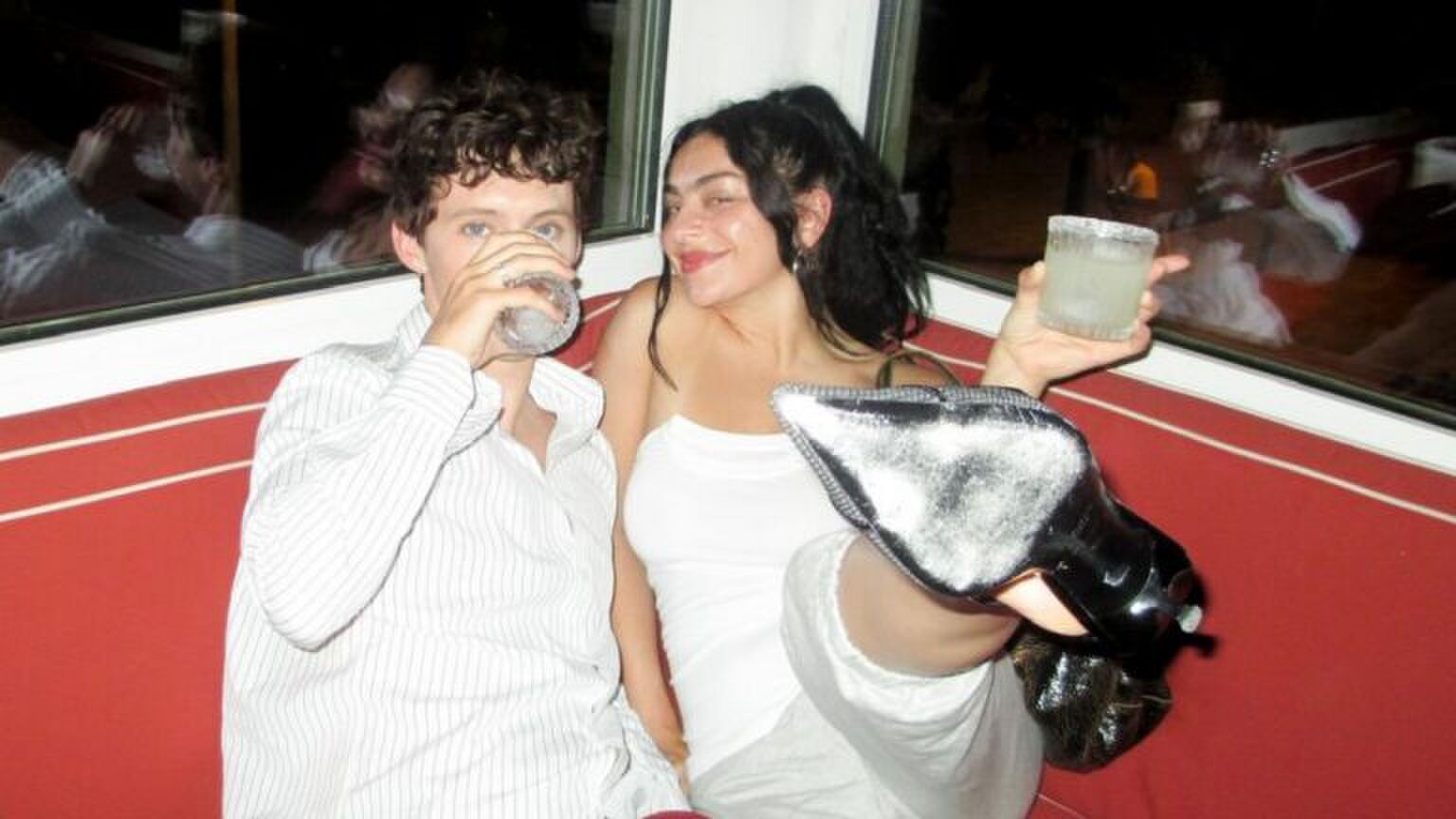 Charli xcx en Troye Sivan drinken samen een drankje.