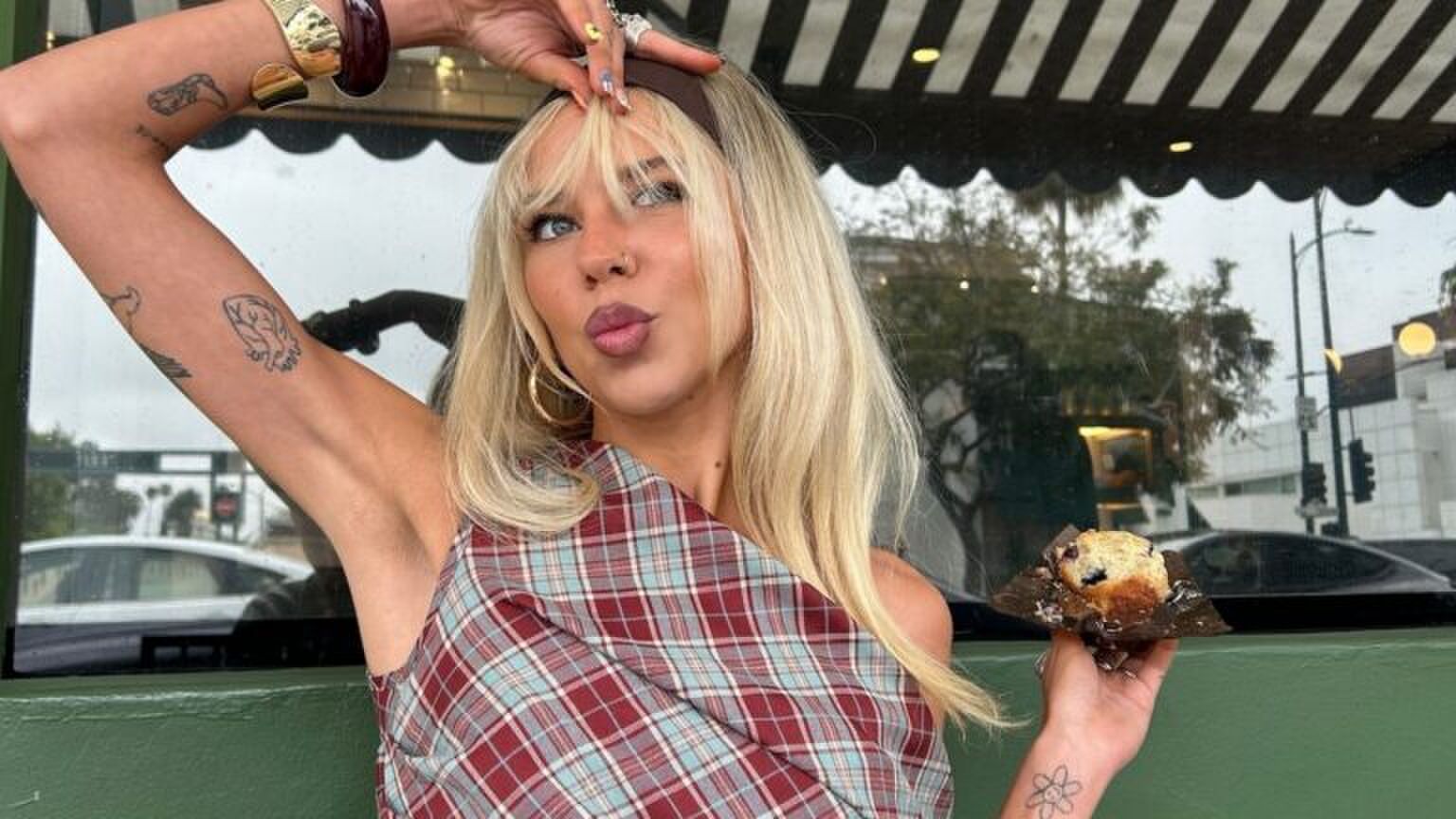 Een jonge vrouw lacht naar de camera.