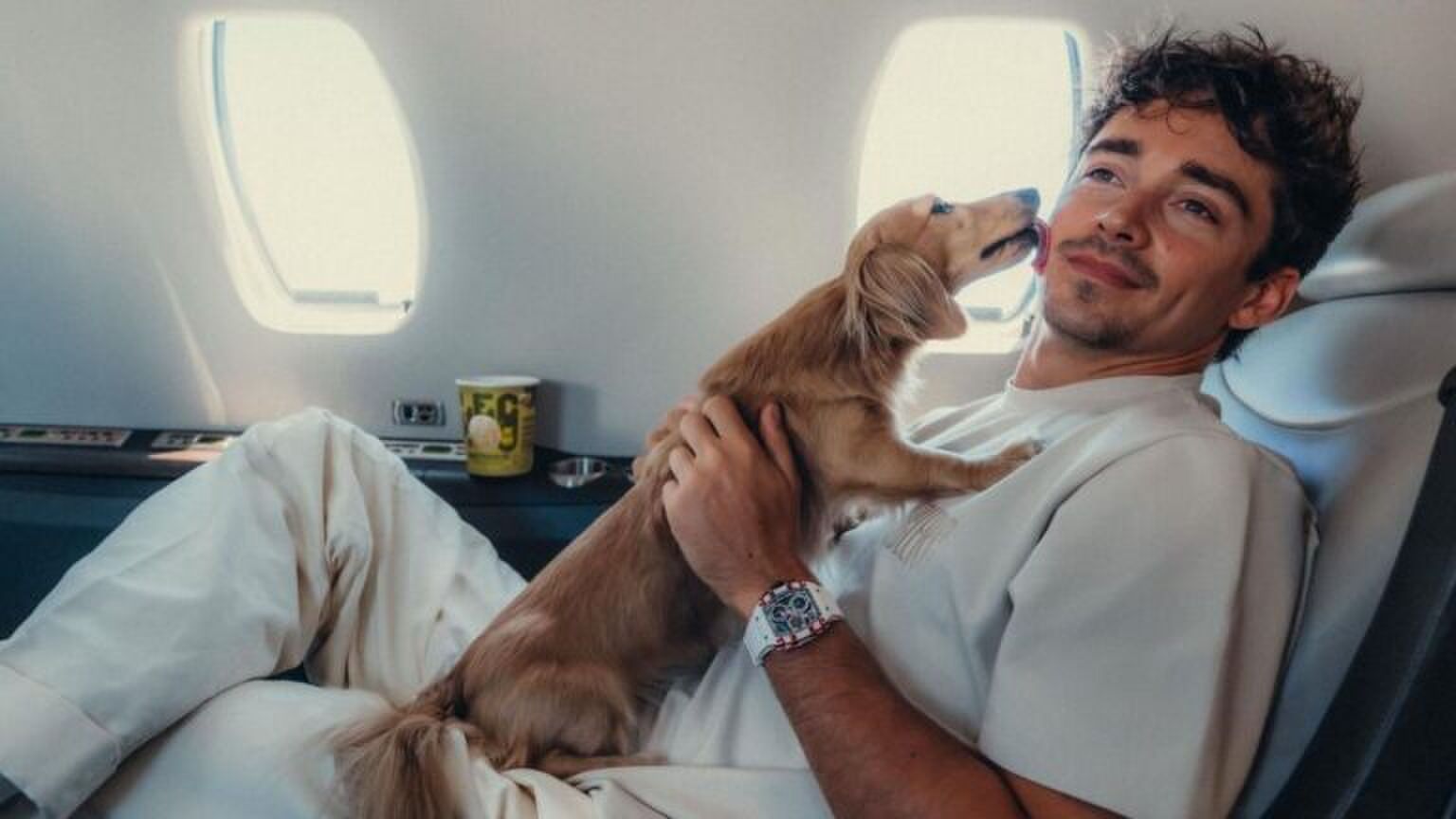 Charles Leclerc knuffelt zijn hond in het vliegtuig.