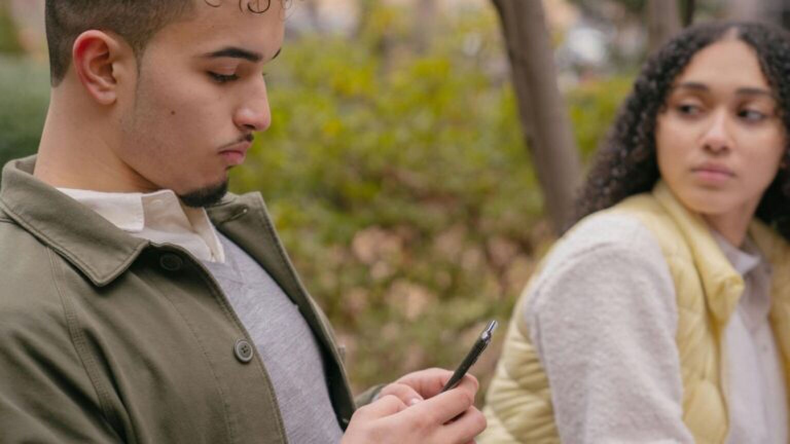 Man en vrouw hebben ruzie. Man kijkt op zijn telefoon tijdens de ruzie.