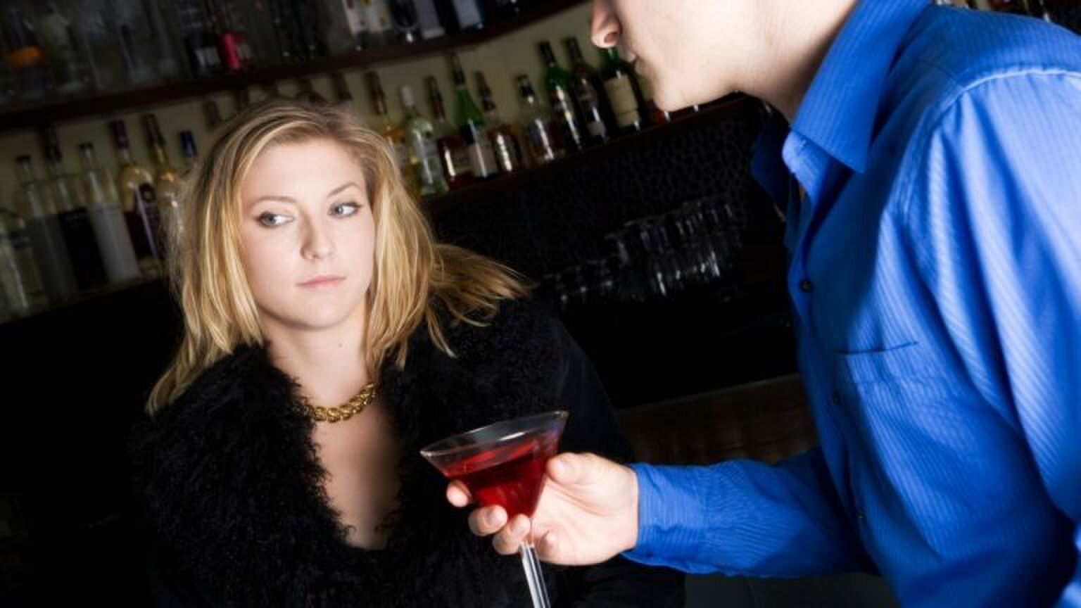 Vrouw is niet ge&iuml;nteresseerd in de man. Hij probeert haar een drankje aan te bieden, maar eigenlijk wilt ze het liever niet.