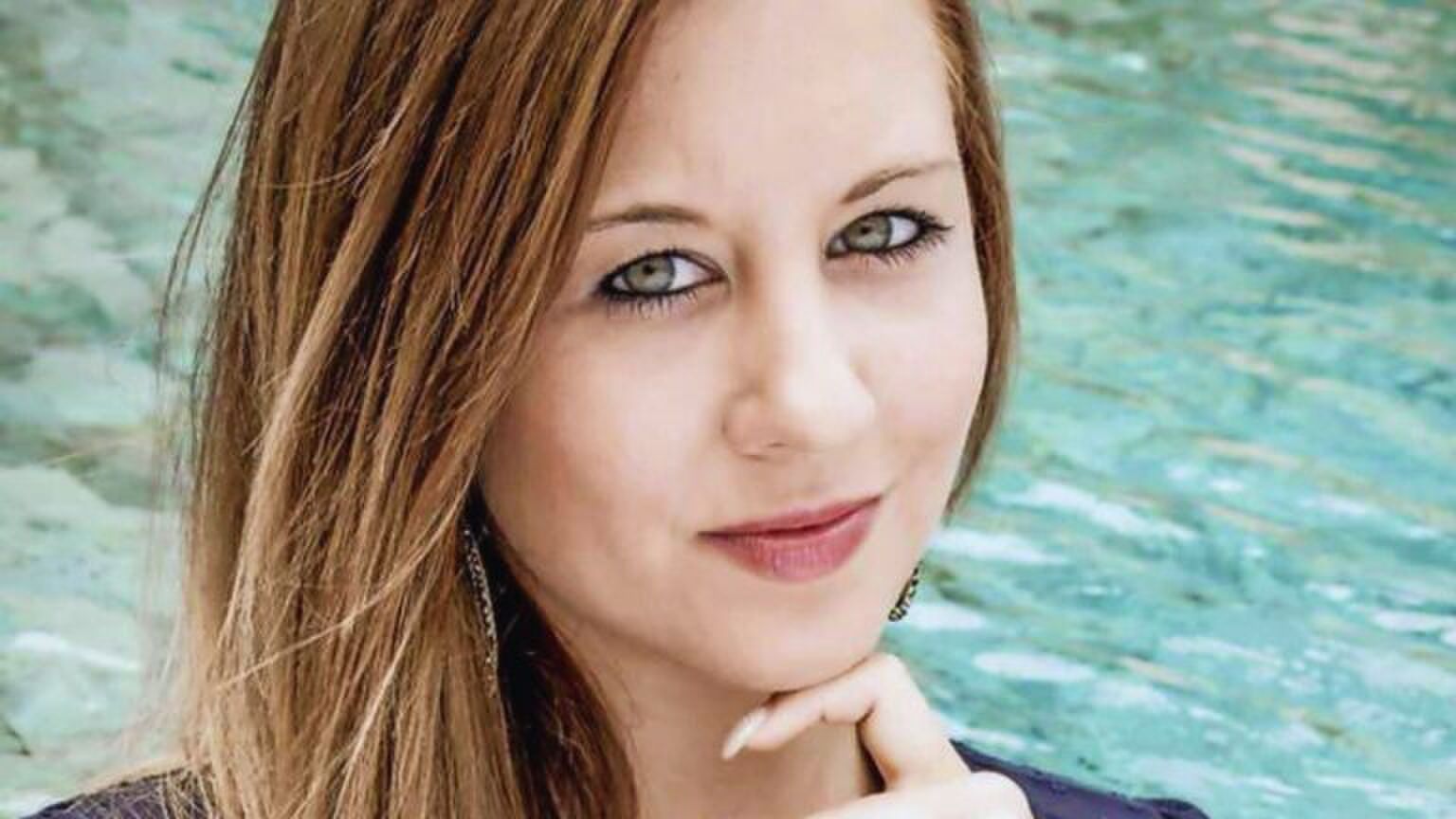 Deborah Leemans van Temptation Island zit bij een zwembad. Ze houdt haar kin met haar wijsvinger vast.