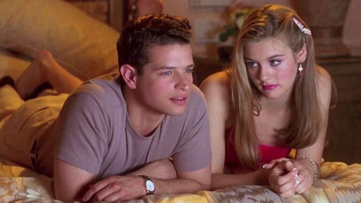 Sc&egrave;ne uit de film clueless. Vrouw en man liggen op bed. Vrouw kijkt heel teleurgesteld naar de man, die alleen maar interesse heeft in de film die ze kijken.