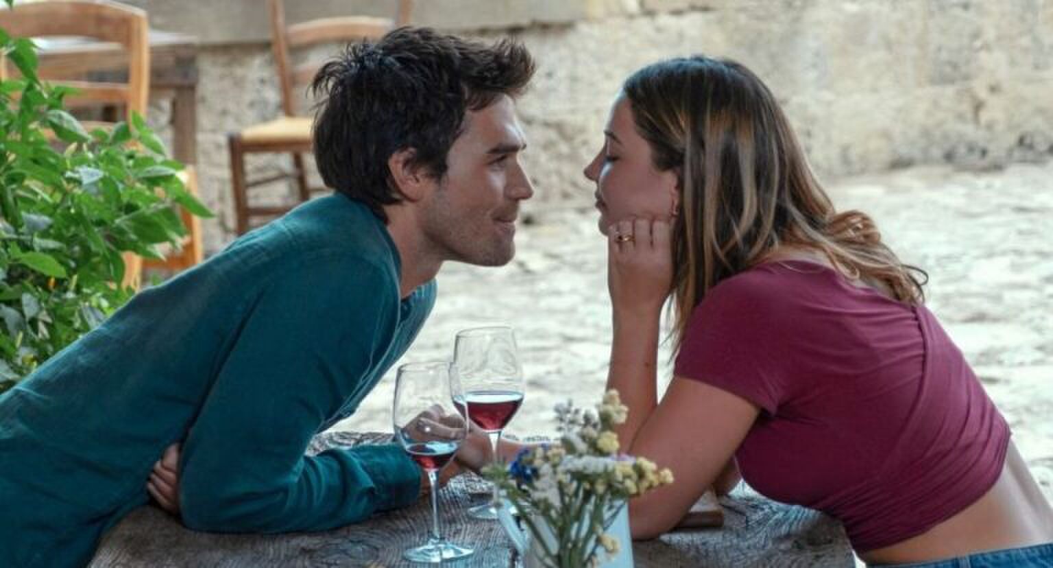 Jongen en meisje kijken elkaar verliefd aan terwijl ze tegenover elkaar zitten.