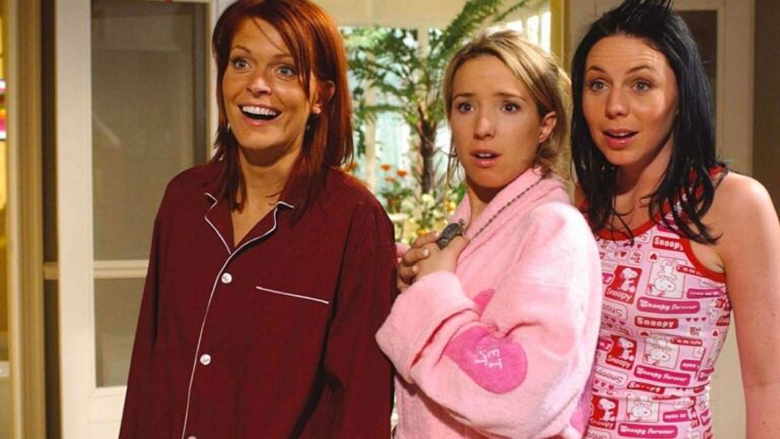 De meiden van de originele K3 staan in hun pyjama's. Ze kijken geschokkeerd.