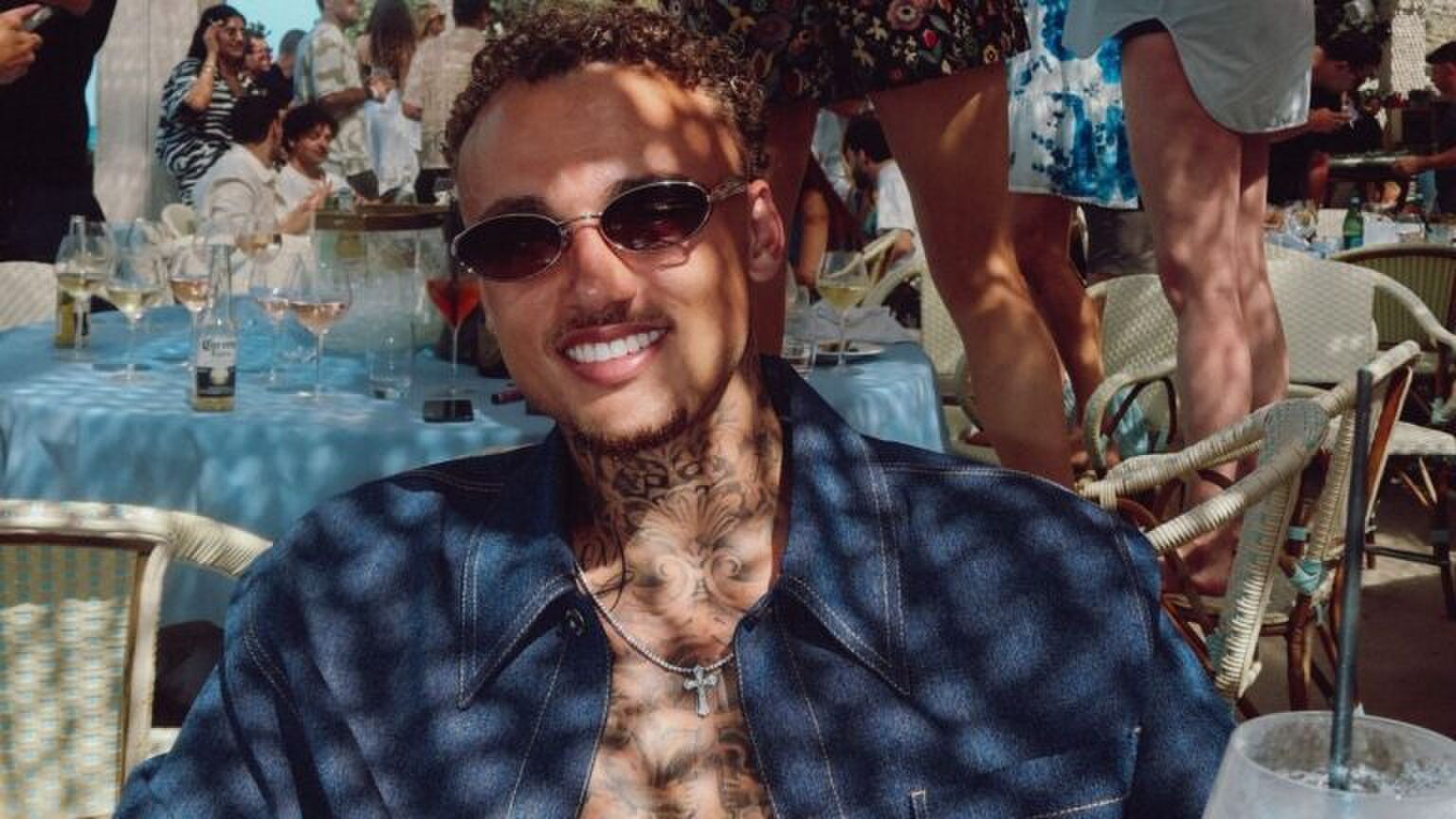 Voetballer Noa Lang kijkt breed lachend voor zicht uit.