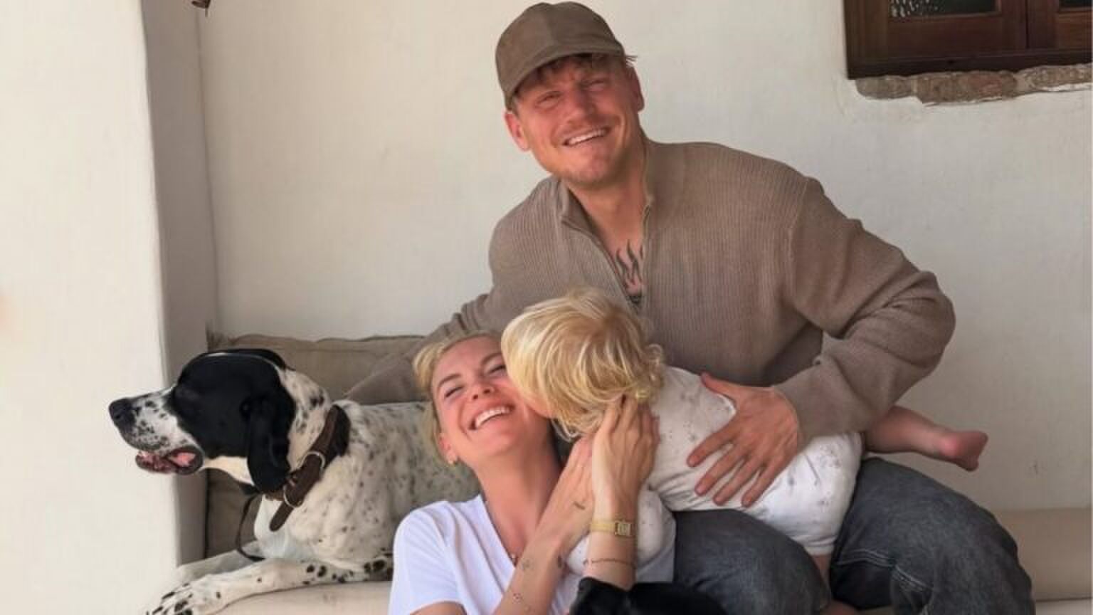 Kaj Gorgels, Jessie Jaz Vuijk en hun kindje Xavier poseren samen met hun hond voor een foto.