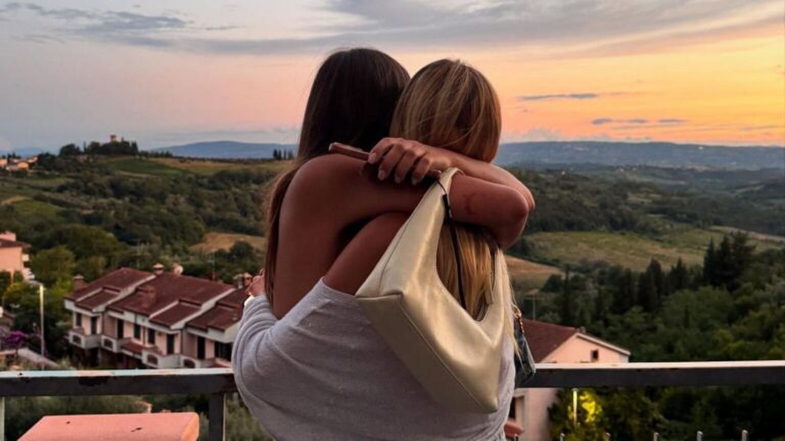 Twee meiden knuffelen met mooi uitzicht.