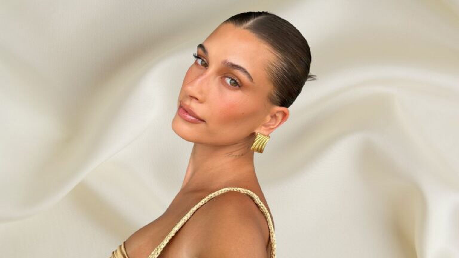 Foto van model Hailey Bieber voor satijnen achtergrond.