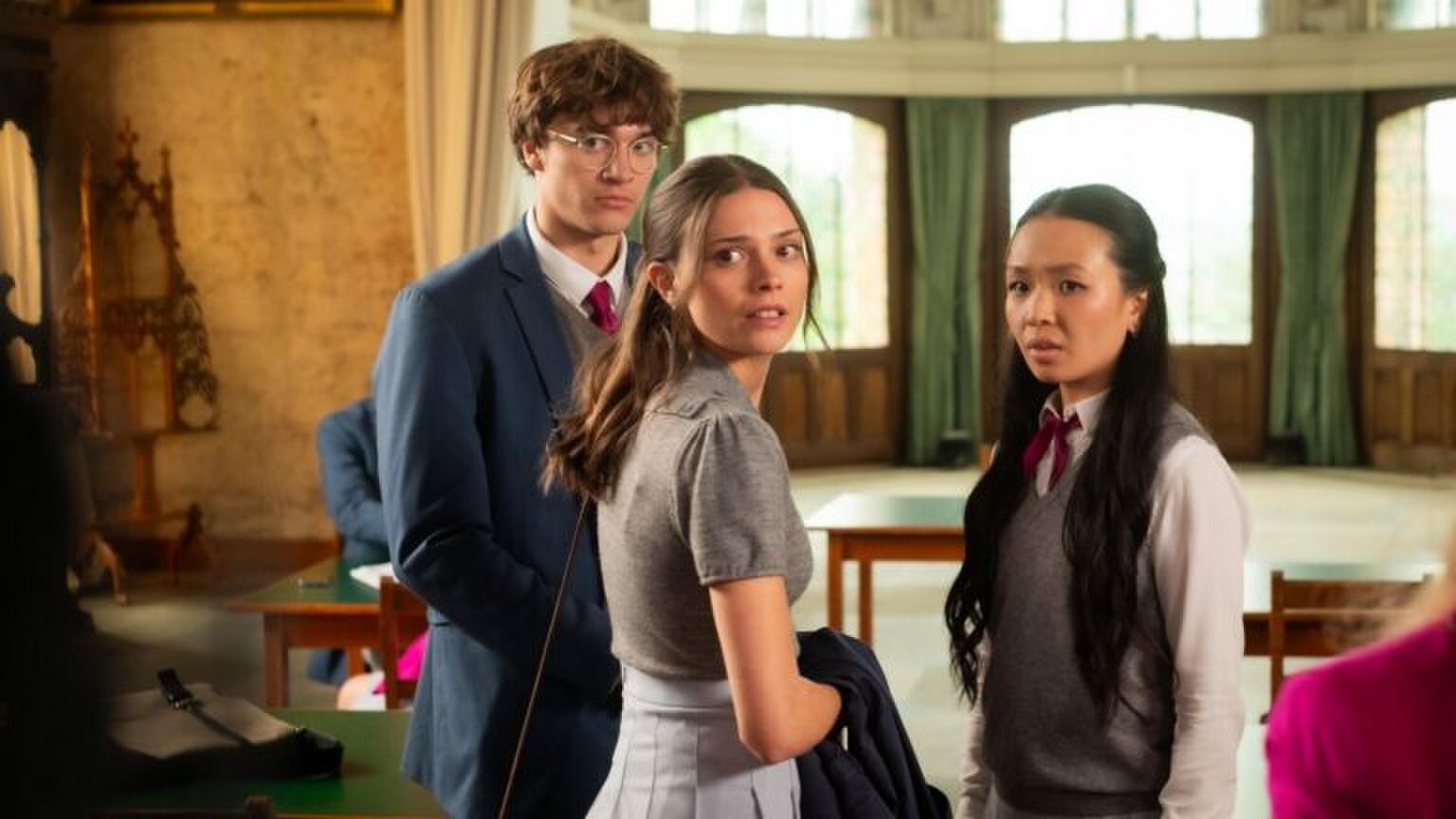 Drie tieners kijken verwachtingsvol naar iemand buiten de camera.