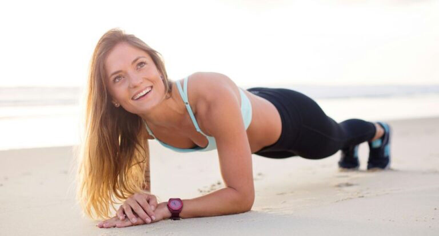 Vrouw die op het strand een plank doet.