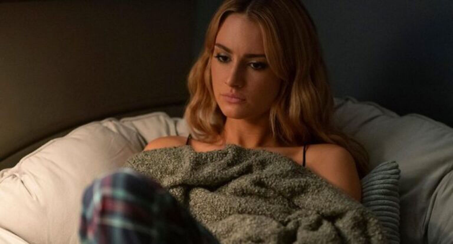 Lucy staart voor zich uit op bed.