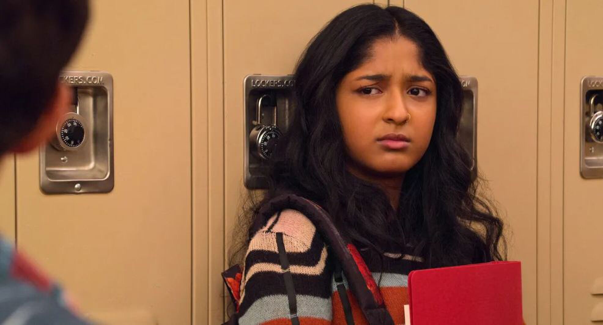 Dewi kijkt in verwarring langs de camera.