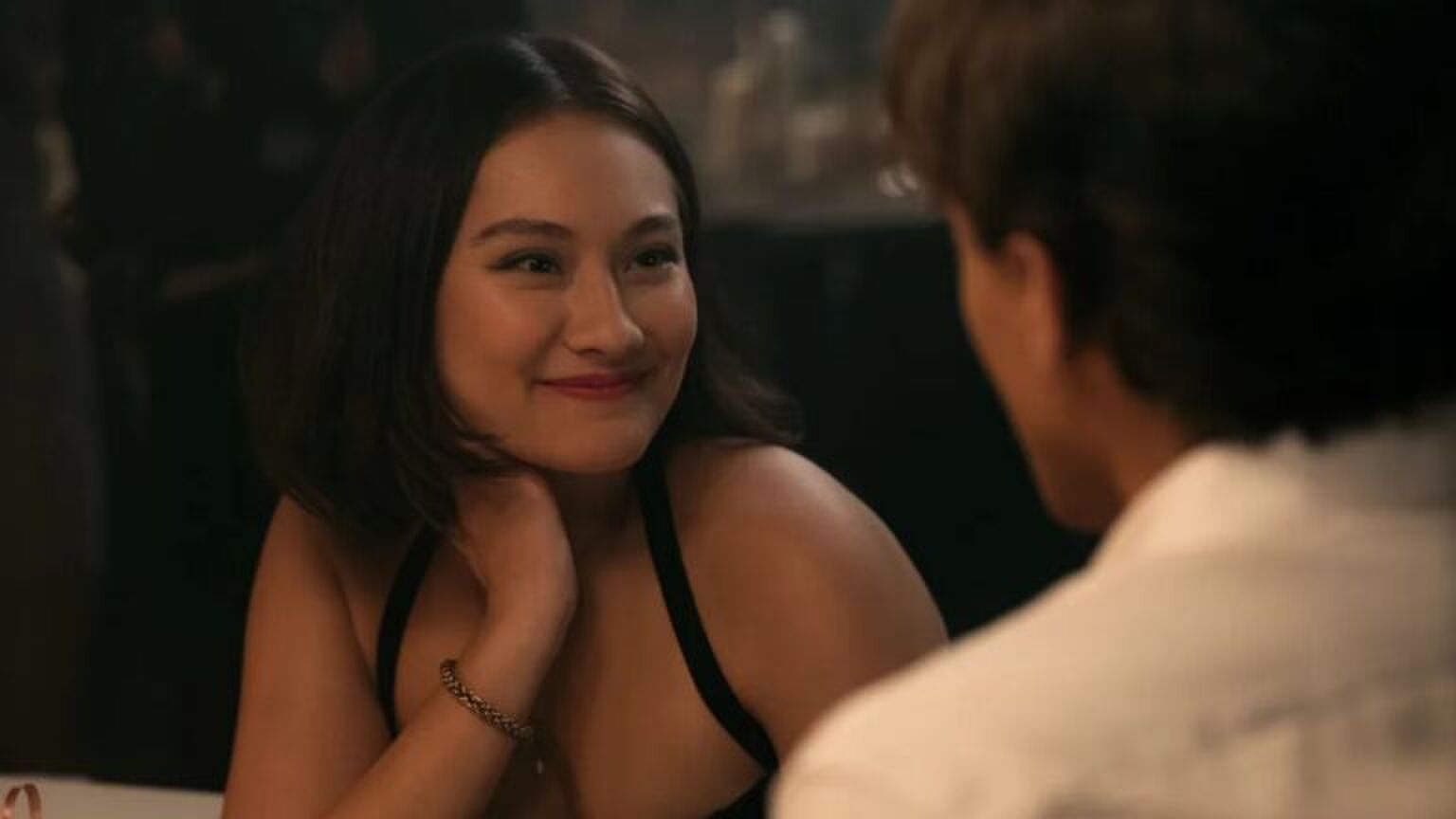 Een jonge vrouw kijkt verliefd naar de man tegenover haar.