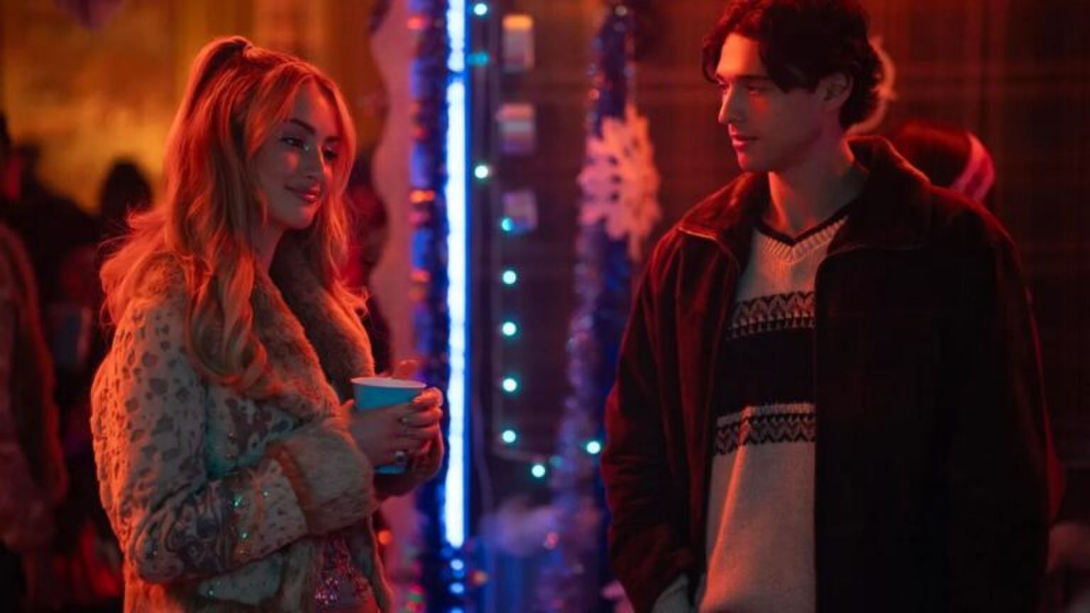 Twee mensen praten op een feestje.