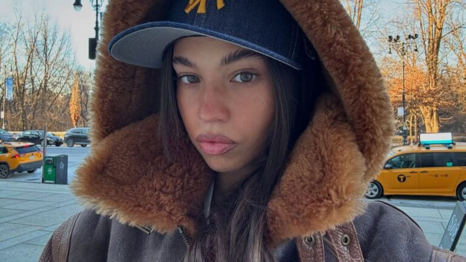 Meisje in winterjas in de sneeuw.